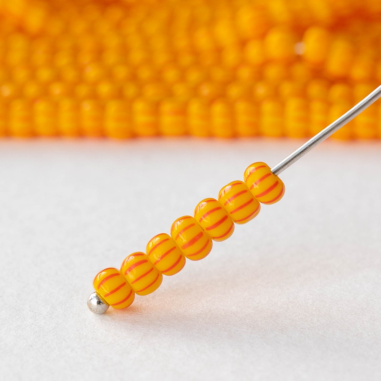 Size 6/0 Glass Seed Beads - Opaque Yellow with Orange Stripes - 20 inch strand