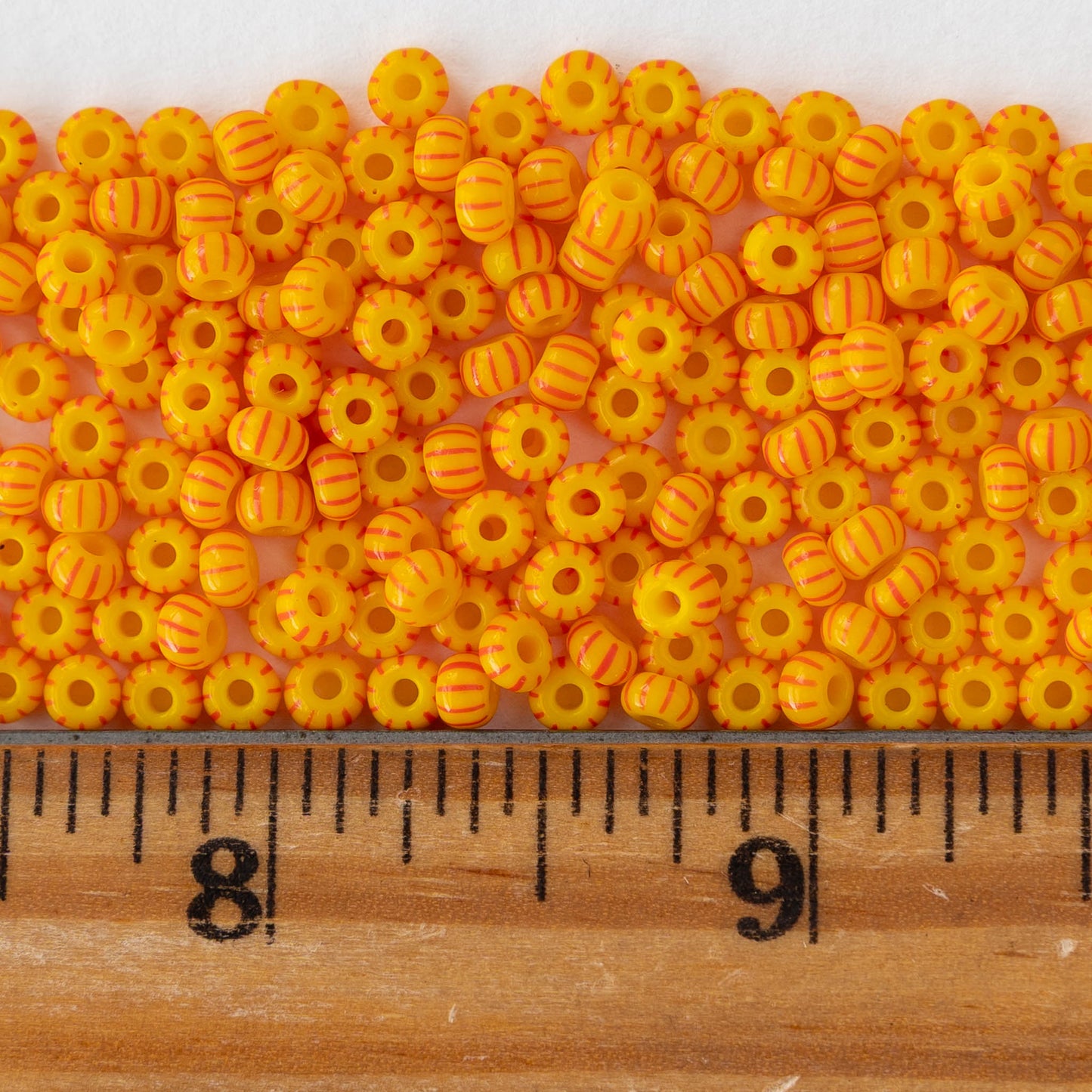Size 6/0 Glass Seed Beads - Opaque Yellow with Orange Stripes - 20 inch strand