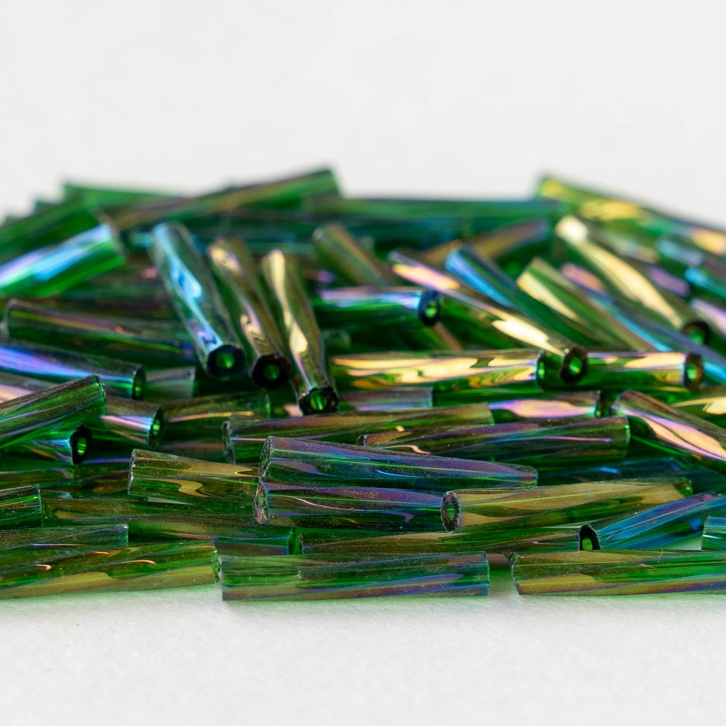 Load image into Gallery viewer, 15mm Twisted Bugle Beads - Transparent Emerald Green Iris - 200 Beads
